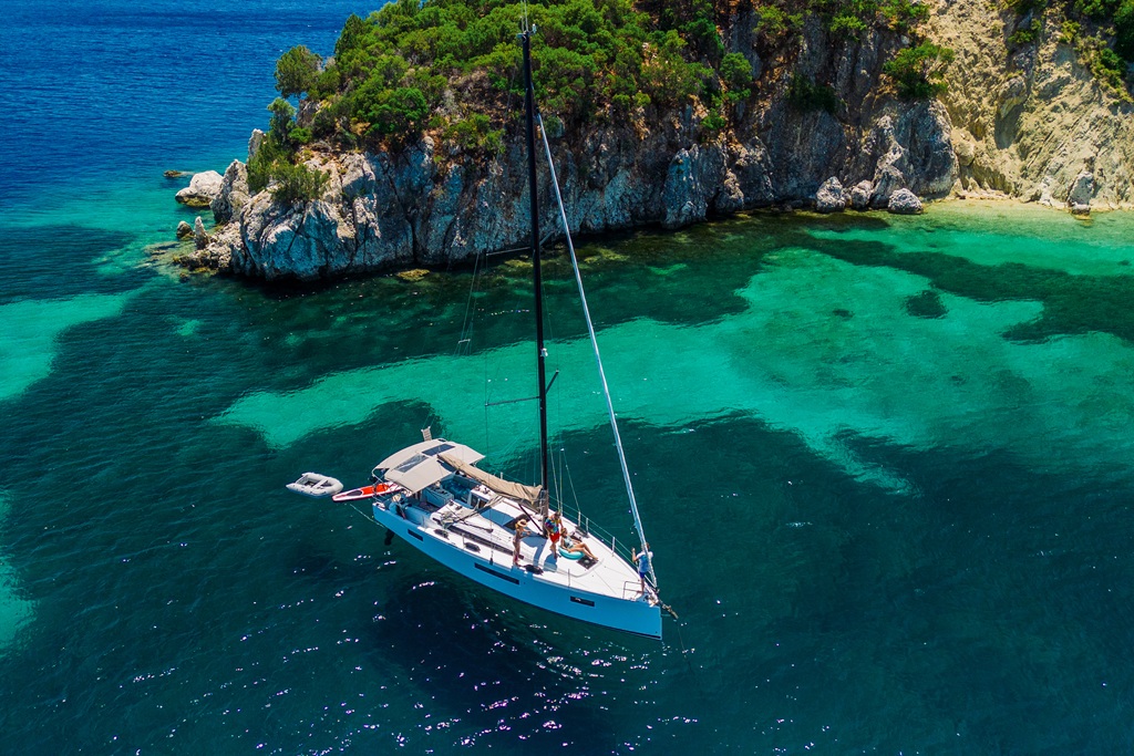 Aerial view of a sailboat in crystal-clear turquoise water, demonstrating the reflection-free benefits of polarized lenses.