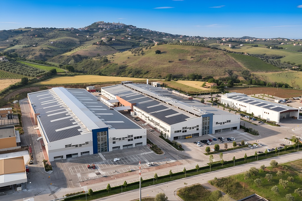 Vista aerea dello stabilimento Barberini con ampi pannelli solari sul tetto, immerso nel paesaggio collinare italiano.